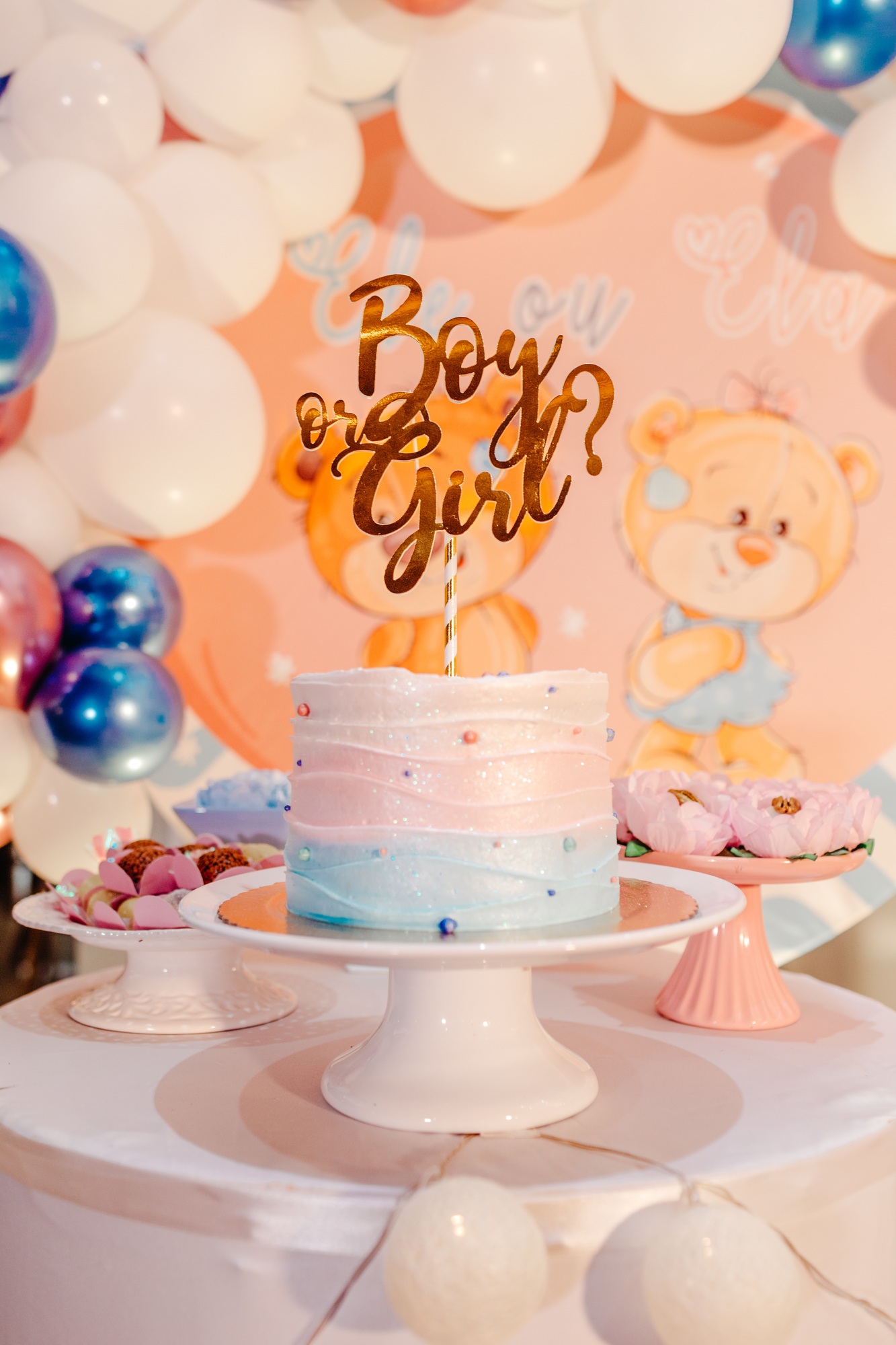 Table with cake sweets and balloons for a gender revealing party